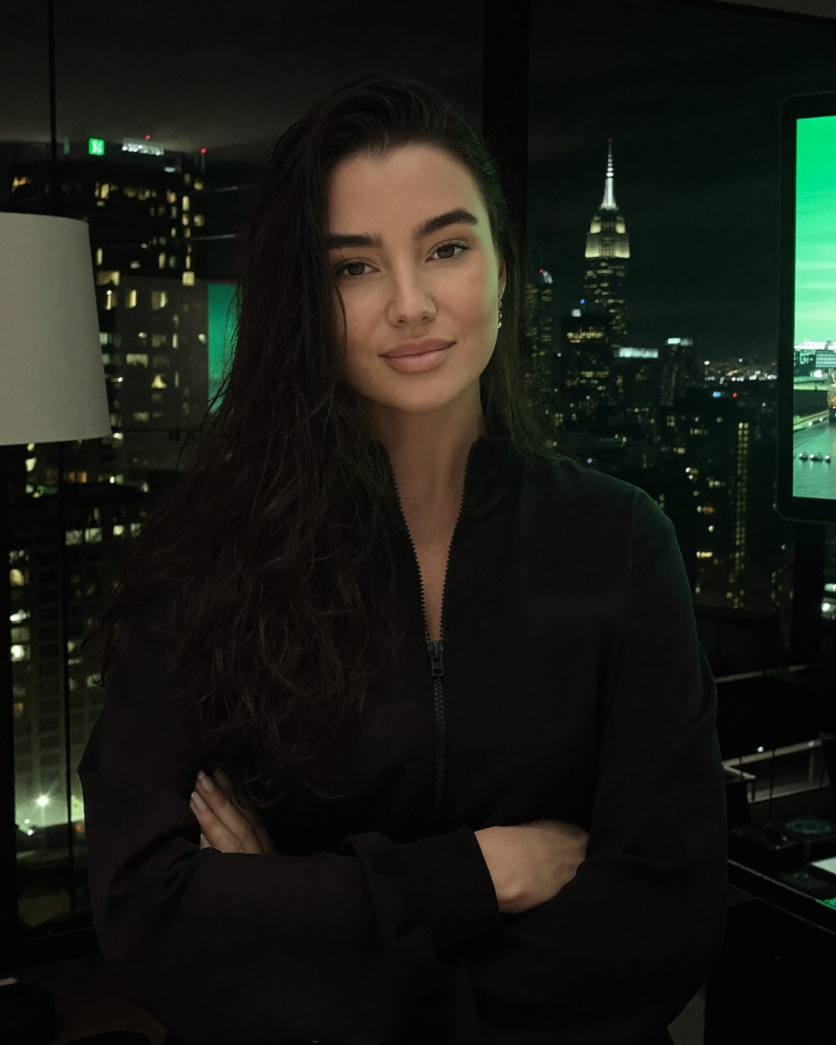 LV, founder of Run Club Academy, in a black track jacket in front of the city at night.